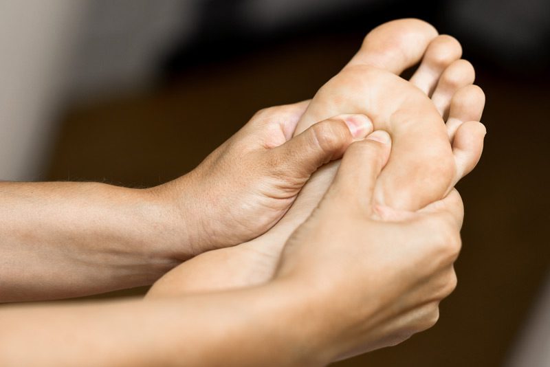 Un podólogo tratando una fascitis plantar a un paciente.